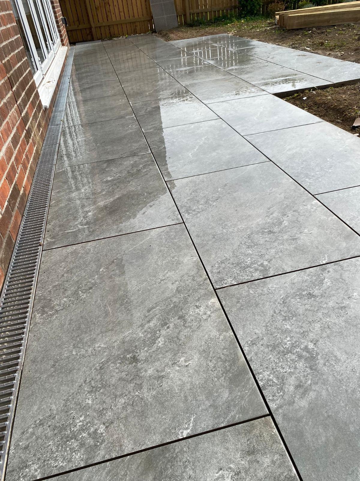Large-format grey porcelain patio with ACO drain — Greater Manchester
