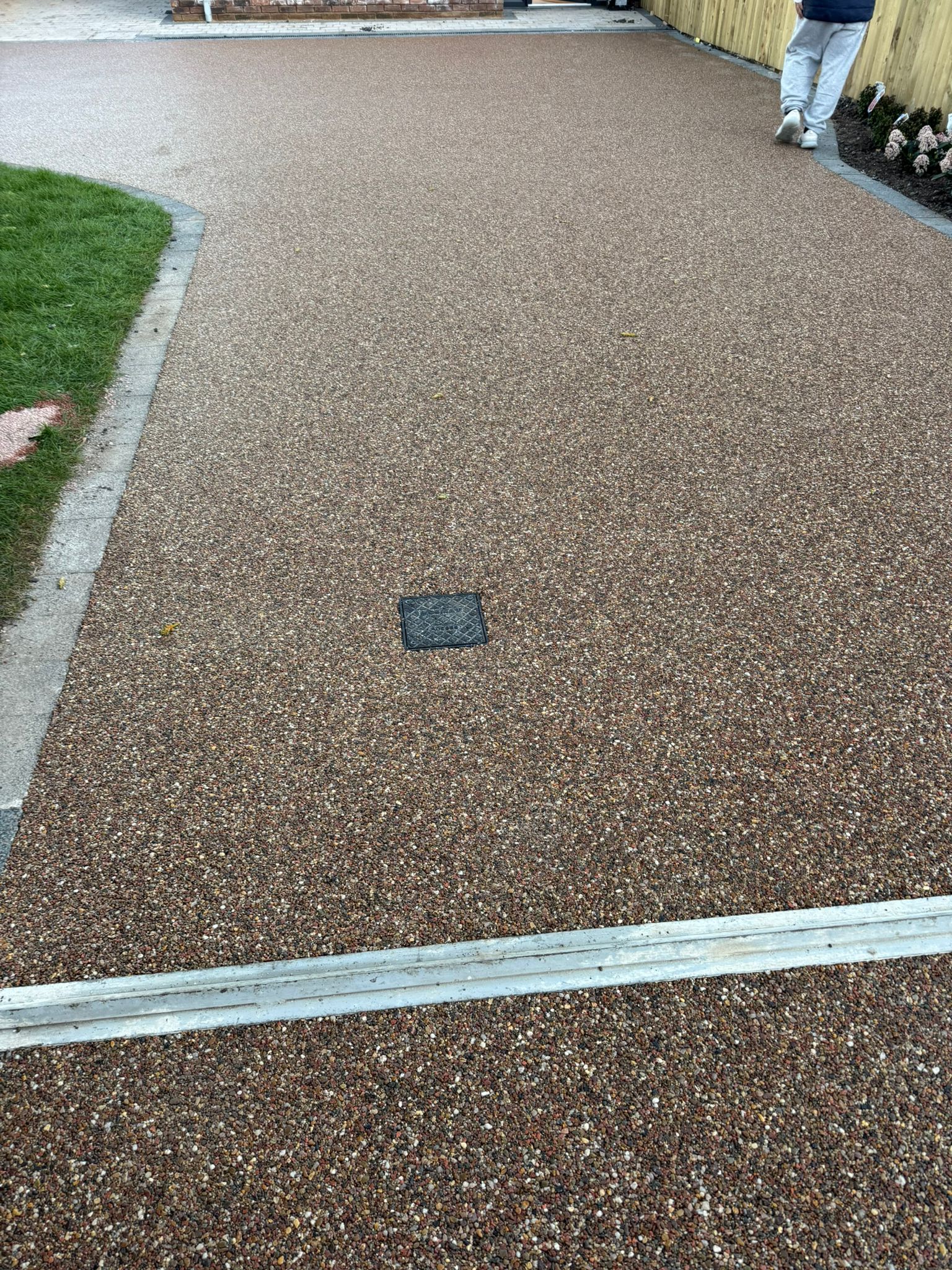 Resin-bound driveway close-up with recessed manhole cover — Sale, Cheshire