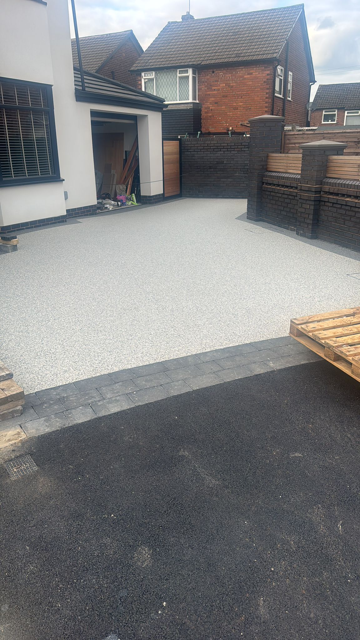 Light resin driveway with dark block border and tarmac apron — North West England