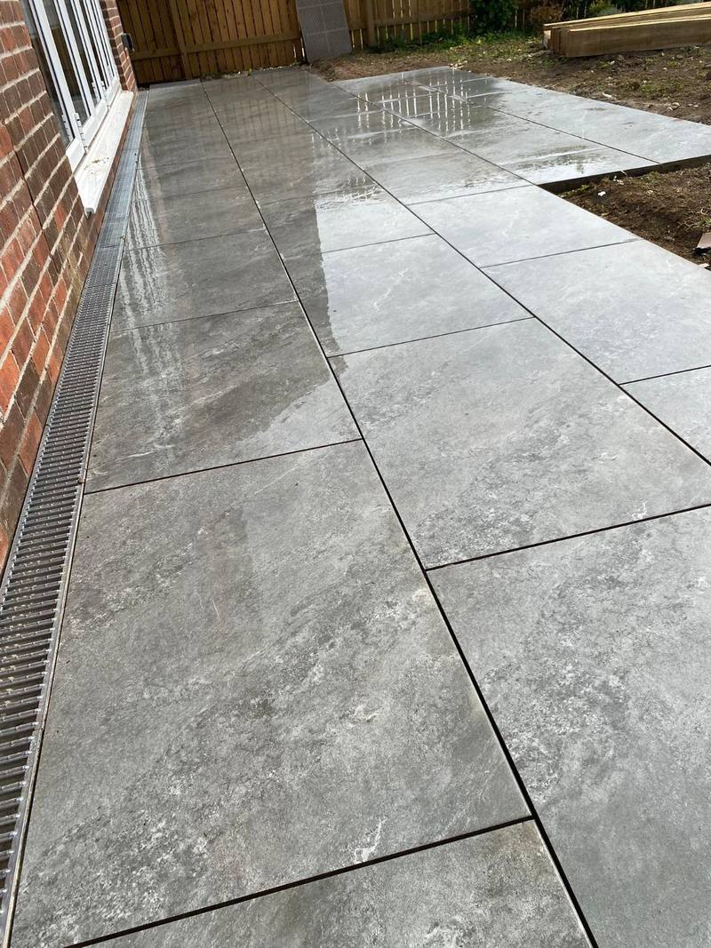 Large-format grey porcelain patio with a linear drainage channel