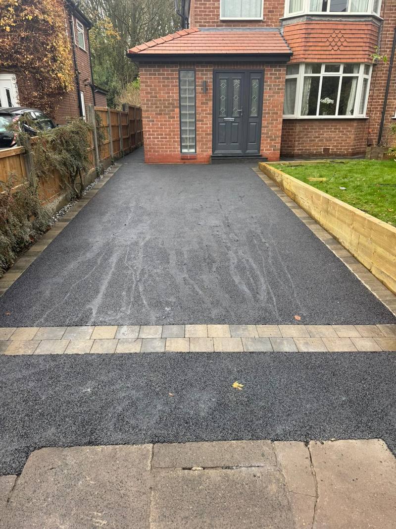 Long tarmac driveway with decorative block strip and sleeper retaining wall